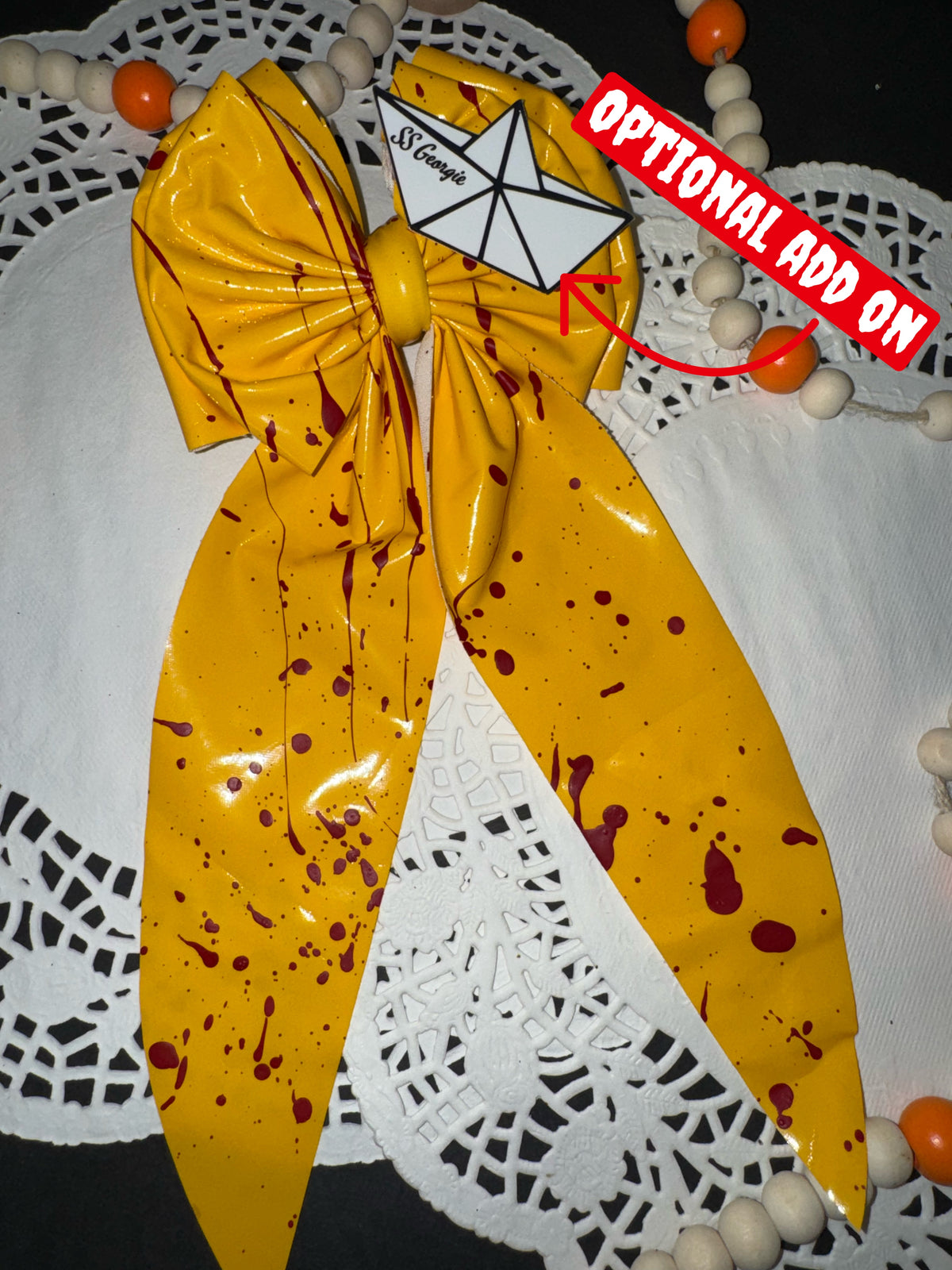 Yellow plastic blood splatter bow